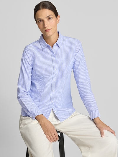 Frauenmodel trägt Hemdbluse aus reiner Baumwolle von Christian Berg Woman, taillierte Passform, hellblau-weiß gestreift, Nahaufnahme Oberkörper.
