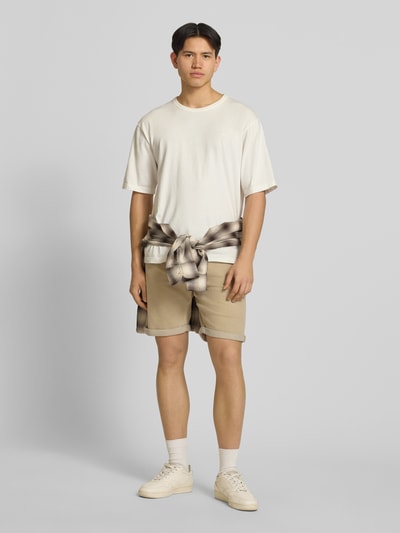 Männermodel trägt Regular Fit Shorts mit Umschlag Modell 'RICK' von Jack & Jones in Beige, Baumwoll-Mix, Eingrifftaschen, Ganzkörperansicht von vorne.