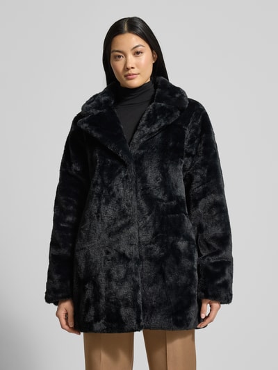 Frauenmodel trägt Damen Jacke mit Reverskragen Modell 'Ay44ssa' von ZABAIONE aus schwarzem Kunstfell, Regular Fit, Ganzkörperansicht von vorne. Rückenlänge 80 cm, Schulterbreite 41 cm, Brustweite 55 cm, Ärmellänge 65 cm.