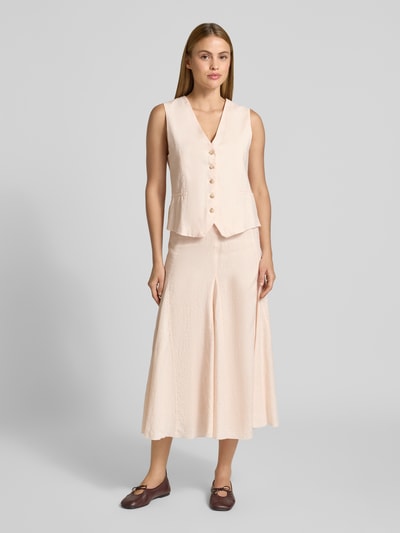 Frauenmodel trägt Leinenrock in A-Linie mit Teilungsnähten von Emily Van den Bergh, Midirock in Beige, reine Leinen, Ganzkörperansicht von vorne.