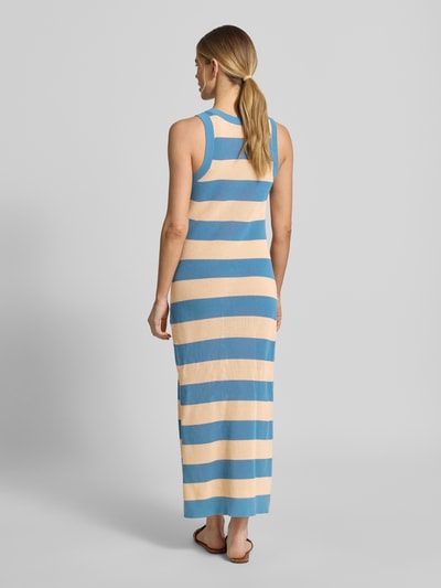 Frauenmodel trägt Enganliegendes Strickkleid aus reiner Baumwolle von Lacoste in Two-Tone-Optik, gestreift, Midi-Länge, Logo-Stitching, Strick, Ganzkörperansicht Rückansicht.