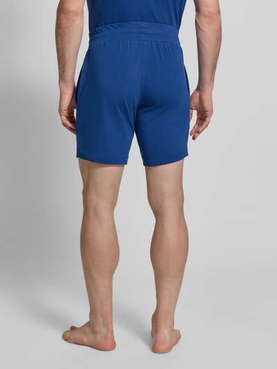 Männermodel trägt Regular Fit Sweatshorts aus Baumwoll-Mix Modell 'LAZE SHORTS CW' von HUGO, Optik: Unifarben, Label-Print, Bundabschluss: elastisch, Ganzkörperansicht Rückansicht.
