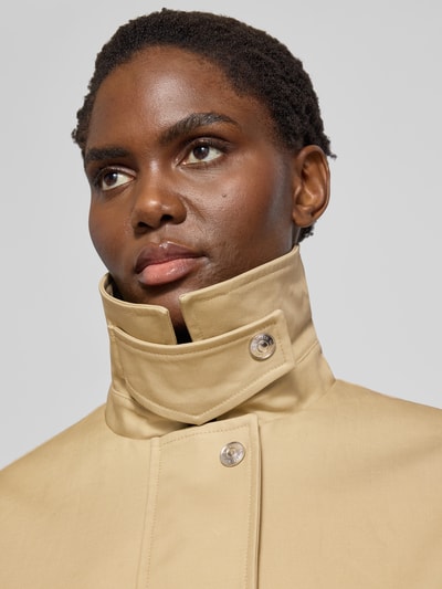 Frauenmodel trägt Jacke mit Label-Stitching von ROTATE in Beige, Reine Baumwolle, Hemdblusenkragen, Nahaufnahme Oberkörper. Lockerer-Schnitt, verdeckter Reißverschluss, Rückenlänge 81 cm, Brustweite 66 cm, Ärmellänge 63 cm.