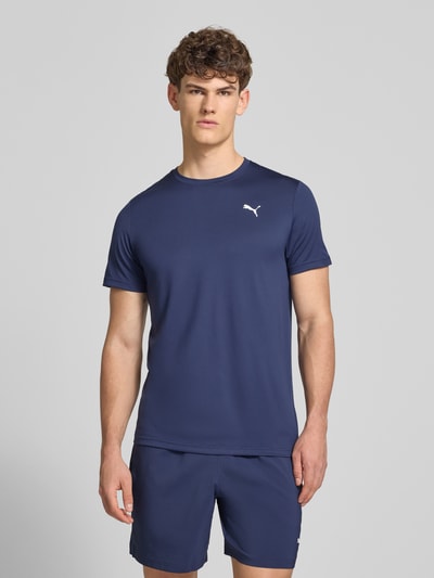 Männermodel trägt Regular Fit T-Shirt mit Logo-Print Modell 'Solid' von PUMA PERFORMANCE in Dunkelblau, Rundhalsausschnitt, Ganzkörperansicht von vorne.
