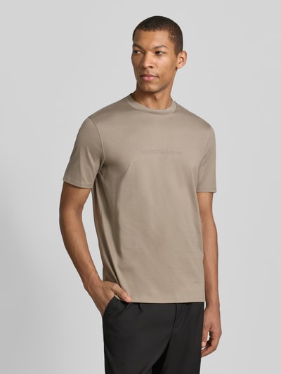 Männermodel trägt Regular Fit T-Shirt mit Logo-Detail von Emporio Armani, Herren T-Shirt aus reiner Baumwolle in Beige, Rundhalsausschnitt, Ganzkörperansicht von vorne. Rückenlänge bei Größe M: 68 cm.