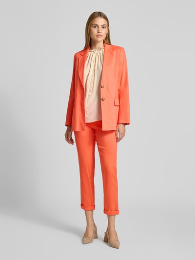 Frauenmodel trägt Blazer aus Leinen-Mix mit Pattentaschen von Marc Cain in Koralle, Reverskragen, gerade Form, Ganzkörperansicht von vorne.