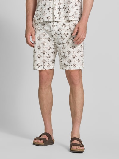 Mannenmodel draagt Relaxed Fit Stoffshorts aus einer Baumwolle van s.Oliver RED LABEL met beige en bruine patronen, detailopname onderlichaam.