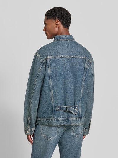 Männermodel trägt Regular Fit Jeansjacke aus Baumwoll-Lyocell-Mix Modell 'AASHTON' von ARMEDANGELS in Blau, Ganzkörperansicht Rückansicht. Herren Jeansjacke