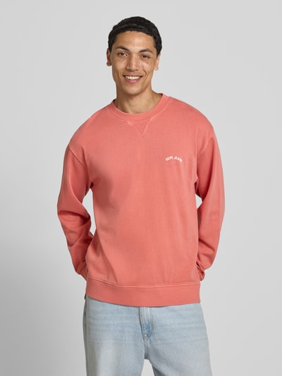 Männermodel trägt Regular Fit Sweatshirt aus reiner Baumwolle Modell 'JOHN CREW' von Pepe Jeans in Koralle, Ganzkörperansicht von vorne, Herren Sweatshirt.