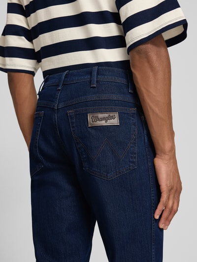 Männermodel trägt Straight Fit Jeans im 5-Pocket-Design Modell 'Texas' von Wrangler, dunkelblaue Baumwoll-Mix, Gerader-Schnitt, Nahaufnahme Rückansicht.