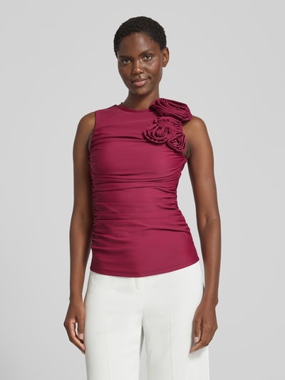 Frauenmodel trägt Slim Fit Bluse mit floralem Besatz Modell 'Orchida' von YAS in Dunkelrot, ärmellos, glatter Stoff, Ganzkörperansicht von vorne.