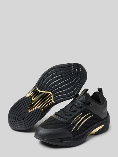 Produktfoto, Sneaker mit Schnürverschluss von PLEIN SPORT in Schwarz-Gold, Material-Mix, abgerundete Spitze, Label-Detail, strukturierte Sohle, Absatzhöhe 7 cm, Schafthöhe und Schaftweite je 7 cm bei Größe 44.