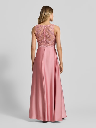 Frauenmodel trägt Abendkleid mit floralem Spitzenbesatz von Laona in Rosa, semitransparente Optik, taillierte Passform, Ganzkörperansicht Rückansicht. Kontext: Ziersteinbesatz, Rückenlänge Größe 36: 142 cm, Brustweite Größe 36: 32 cm, ärmelloses Design.