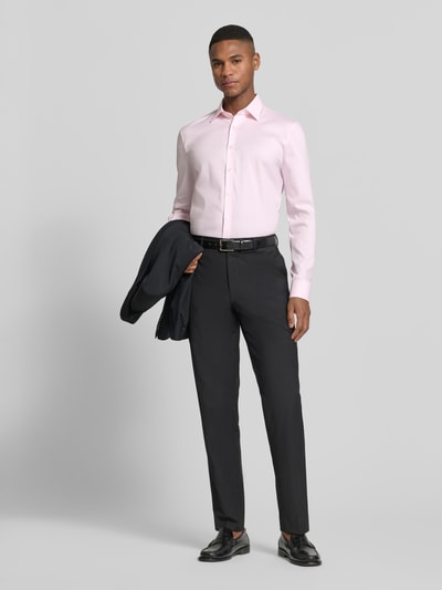 Männermodel trägt Slim Fit Businesshemd mit Kentkragen von OLYMP No. Six in Hellrosa, Baumwoll-Mix, Langärmelig, Sportmanschetten, Ganzkörperansicht von vorne.