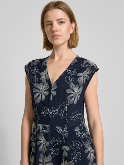 Frauenmodel trägt Midikleid mit Stitchings und Eingrifftaschen von Milano Italy, dunkelblauer Baumwoll-Mix, florale Stickerei, Nahaufnahme Oberkörper.