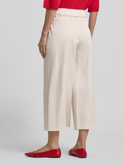 Vrouwenmodel draagt Culotte met elastische tailleband en strikriem van Marc Cain, beige katoenmix met viscose, wijde pijp, rugaanzicht.