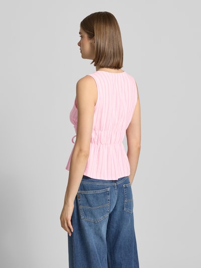 Frauenmodel trägt Top aus Viskose-Leinen-Mix Modell 'ALMIRA' von JJXX in Rosa mit feiner Struktur und Schnürung, Rückenlänge 50 cm, Ganzkörperansicht Rückansicht.