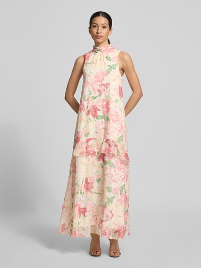 Vrouwenmodel draagt Fließendes Maxikleid met Rüschendetail model 'SANNA' van Vero Moda, look: all-over bloemenmotief, maxi-jurk, fließende pasvorm, maxilengte, hooggesloten hals, zonder mouwen, V-hals rugdecolleté met strik, volantzoom, ruchedetail, onderjurk, materiaalverwerking: chiffon, vooraanzicht volledige lichaamsopname