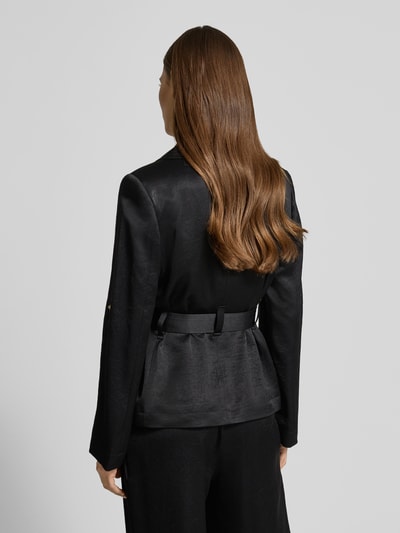 Frauenmodel trägt Blazer mit Reverskragen von Marc Cain aus schwarzem Acetat-Mix, taillierter Schnitt, Taillengürtel, Knopfverschluss, Rückenlänge 61 cm, Brustweite 46 cm, Ärmellänge 62 cm, Ganzkörperansicht Rückansicht.