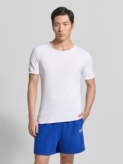 Männermodel trägt Slim Fit T-Shirt mit Rundhalsausschnitt Modell 'Sonoma' von American Vintage in Weiß, schlichte Optik, Ganzkörperansicht von vorne.