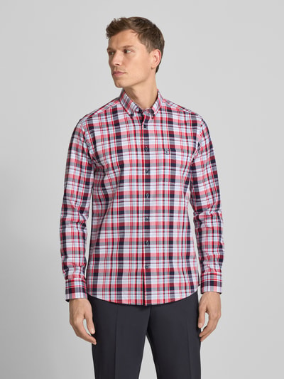 Männermodel draagt een rood-wit-blauw geruit Bugatti heren vrijetijdsoverhemd van puur katoen, regular fit, button-downkraag, knoopsluiting, borstzak en labelstitching, ruglengte maat M 78 cm, schouderbreedte maat M 45 cm, mouwlengte maat M 66 cm. Ganzkörperansicht von vorne.