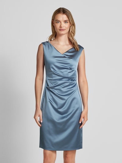 Frauenmodel trägt Cocktailkleid mit Wasserfall-Ausschnitt von Vera Mont in Blau, taillierter Schnitt, ärmellos, Material-Mix, Ganzkörperansicht von vorne.