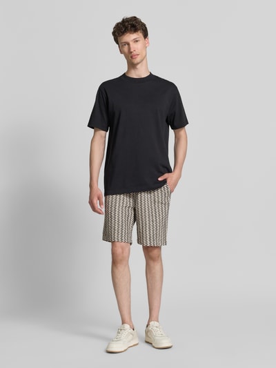Männermodel trägt Relaxed Fit Stoffshorts aus Baumwoll-Mix von s.Oliver RED LABEL, Optik:Allover-Muster, Strukturmuster, Label-Patch, Bundabschluss: elastisch mit Tunnelzug, seitliche Eingrifftaschen, Gesäßtasche, Material: Reine Baumwolle; helle, strukturierte Shorts mit Muster auf glattem Hintergrund, Ganzkörperansicht von vorne.