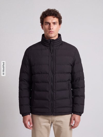 Männermodel trägt schwarze Regular Fit Steppjacke mit Stehkragen Modell 'MODENA FUSED' von Strellson, Herren Steppjacke, Ganzkörperansicht von vorne, KI-modifiziertes Bild.