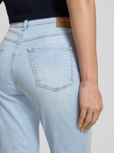 Kobiece modelka nosi jasnoniebieskie Slim Fit Jeans aus Baumwoll-Mix Modell 'DREAM SUMMER' od MAC, szwy w kontrastowym kolorze, naszywka z logo, 5 kieszeni, mieszanka bawełny i modalu, skrócony krój, zapięcie na guzik i zamek błyskawiczny, szerokość w rozmiarze 36/28: 39 cm, długość wewnętrzna nogawki: 68 cm, widok z tyłu na wysokości bioder.