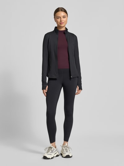 Frauenmodel trägt Slim Fit Longsleeve mit Stehkragen von Fabletics, Elastischer-Material-Mix, Langärmelig, Rückenlänge 50 cm, Ganzkörperansicht von vorne.