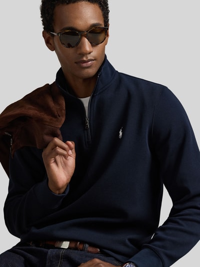 Männermodel trägt Relaxed Fit Troyer aus Baumwoll-Mix von Polo Ralph Lauren in Dunkelblau, glatte Textur, Nahaufnahme Oberkörper. Herren Troyer.