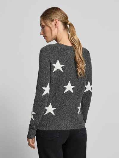 Frauenmodel trägt Regular Fit Pullover mit Rundhalsausschnitt Modell 'DOFFY' von VERO MODA in Dunkelgrau mit weißen Sternen, Ganzkörperansicht Rückansicht.