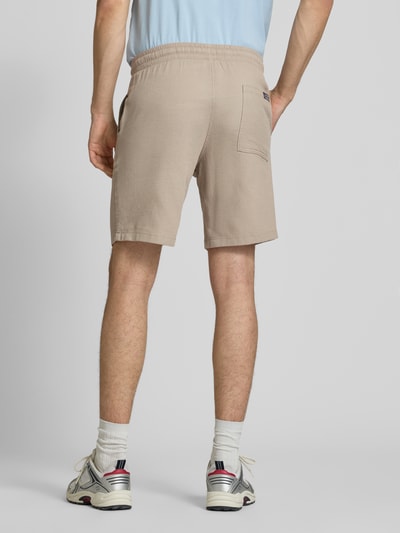Męski model nosi Shorts mit Strukturmuster Modell 'JAIDEN' od Jack & Jones, beżowy, bawełna, krój regular fit, elastyczny pas, tunel, struktura, szerokość w rozmiarze M: 43 cm, długość nogawki wewnętrznej w rozmiarze M: 23 cm, widok całej sylwetki z tyłu.
