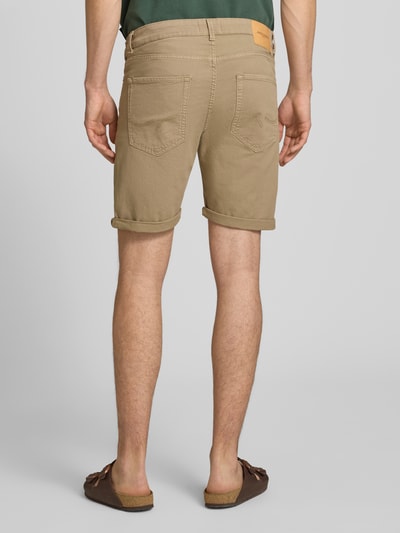 Männermodel trägt Jeansshorts mit Umschlag und Eingrifftaschen Modell 'RICK ALLEN' von Jack & Jones, beige, Baumwoll-Elasthan-Mix, Ganzkörperansicht Rückansicht.