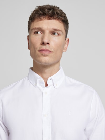 Männermodel trägt Regular Fit Freizeithemd aus reiner Baumwolle Modell 'QUAASA' von Armedangels, unifarben weiß, Nahaufnahme Oberkörper.