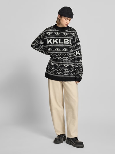 Frauenmodel trägt Jacquard-Strickpullover mit Rundhalsausschnitt von Karo Kauer, schwarz-weiß, Relaxed Fit, Ganzkörperansicht von vorne.