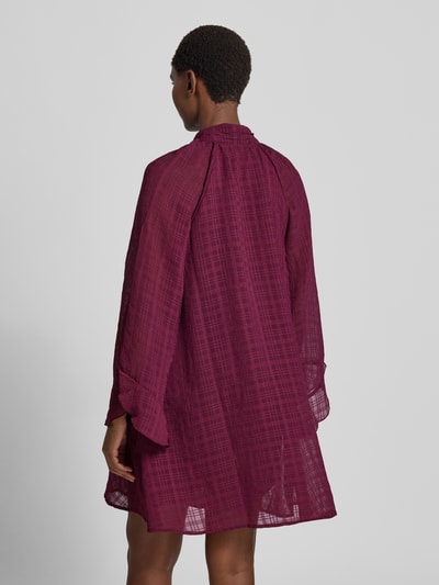 Vrouwenmodel draagt mini-jurk met strik, loose fit, opstaande kraag, semitransparante mouwen, onderjurk, Model 'LIANA' van YAS, ruglengte maat 36 88 cm, borstwijdte 47 cm, mouwlengte 46 cm, rugaanzicht.