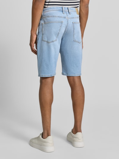 Männermodel trägt Regular Fit Jeans-Bermudas aus Baumwoll-Mix von s.Oliver RED LABEL in heller Denim-Optik mit Kontrastnähten, 5-Pocket-Design, Label-Patch, Nieten, Baumwoll-Mix Material, Ganzkörperansicht Rückansicht.