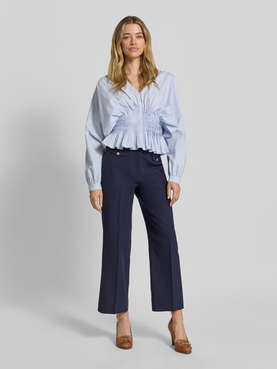 Vrouwenmodel draagt Straight Fit Leinenhose met Viskose-Anteil Modell 'Alara' van SEDUCTIVE in donkerblauw, met persvouwen, sierknopen, paspelzakken en elastische linnenmix, Ganzkörperaanzicht van voren.