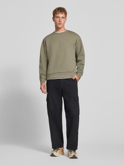 Męski model nosi Regular Fit Sweatshirt mit Baumwoll-Anteil od JACK & JONES, Mieszanka materiałów, krój regular fit, okrągły dekolt, elastyczne wykończenia, krój z długim rękawem, długość tyłu w rozmiarze M: 65 cm, długość rękawów w rozmiarze M: 59 cm, stonowane kolory, prosta faktura, gładka tkanina, pełen widok z przodu