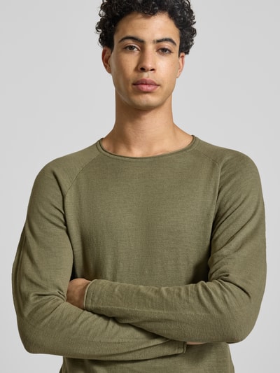 Männermodel trägt Regular Fit Longsleeve mit Logo-Patch Modell 'Breeze' von JACK & JONES, reine Baumwolle, Strick-Optik, Rundhalsausschnitt, Nahaufnahme Oberkörper.