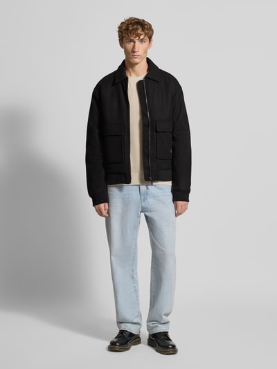 Männermodel trägt Jacke mit Reißverschluss von Pegador in Schwarz, Material-Mix mit Viskose-Anteil, Regular-Fit, Kentkragen, Pattentaschen, Label-Stitching, gerippte Abschlüsse, Maße bei Größe M: Rückenlänge 69 cm, Schulterbreite 48 cm, Brustweite 48 cm, Ärmellänge 75 cm, Ganzkörperansicht von vorne.