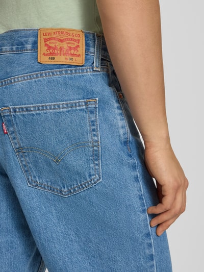 Männermodel trägt Loose Fit Jeansshorts aus reiner Baumwolle Modell '469' von Levi's®, Denim-Optik, Label-Patch, Detailaufnahme Rückansicht.