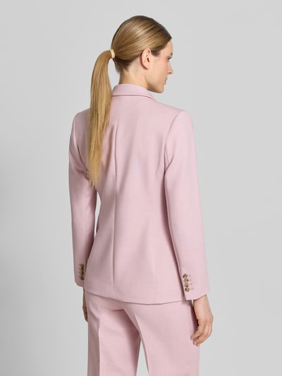 Männermodel trägt Regular Fit Longblazer mit Reverskragen Modell 'RITA' von Selected Femme, różowy, tkanina gładka, krój regular fit, długość do bioder, długi rękaw z mankietami na guziki, klapy z klapami, zdjęcie całej sylwetki z tyłu.