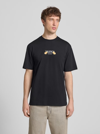 Männermodel trägt schwarzes Only & Sons Relaxed Fit T-Shirt aus reiner Baumwolle mit Front-Schriftzug, Ganzkörperansicht von vorne.