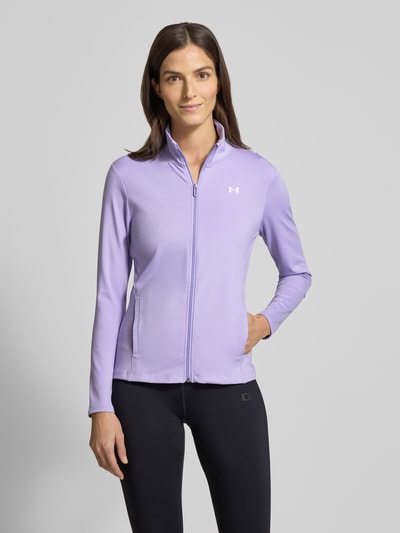 Frauenmodel trägt Motion Jacket mit Logo-Print Modell 'EMEA' von Under Armour in Flieder, körpernaher Schnitt, Stehkragen, Reißverschluss, seitliche Reißverschlusstaschen, glatte Textur, Ganzkörperansicht von vorne.