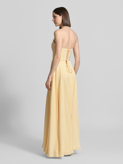 Frauenmodel trägt Maxikleid im Off-Shoulder-Look von Luxuar in Gelb, taillierter Schnitt, Gehschlitz, Rückseite mit Schnürung, Ganzkörperansicht Rückansicht. Rückenlänge bei Größe 36: 134 cm, Brustweite 43 cm.