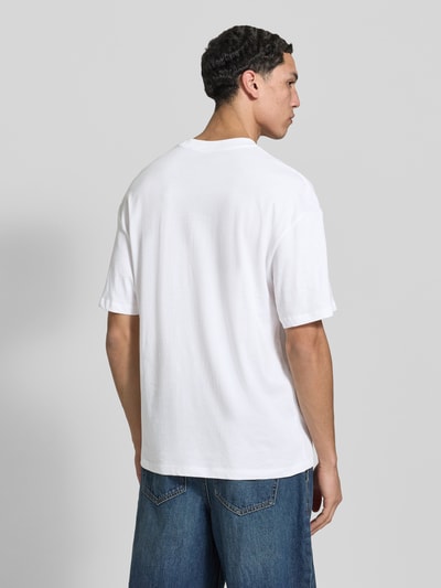 Männermodel trägt T-Shirt mit Rundhalsausschnitt Modell 'BRADLEY' von Jack & Jones in Weiß, reine Baumwolle, Regular Fit, Ganzkörperansicht Rückansicht.