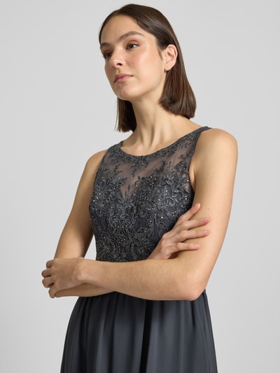 Frauenmodel trägt Abendkleid mit Ziersteinen und floralen Stickereien von LAONA, taillierte Passform, Rundhalsausschnitt, Nahaufnahme Oberkörper.