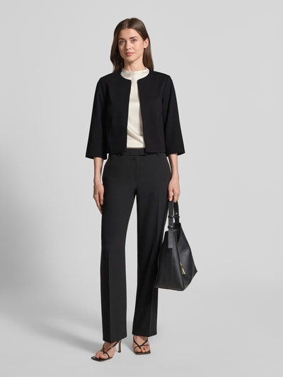 Modelka kobieca nosi Blazer aus Viskose-Mix mit offener Front od Betty Barclay, czarny, prosty krój, okrągły dekolt, 3/4 rękaw, długość pleców w rozmiarze 36: 43 cm, szerokość w rozmiarze 36: 45 cm, długość rękawa w rozmiarze 36: 39 cm, tkanina elastyczna, widok całej sylwetki z przodu.